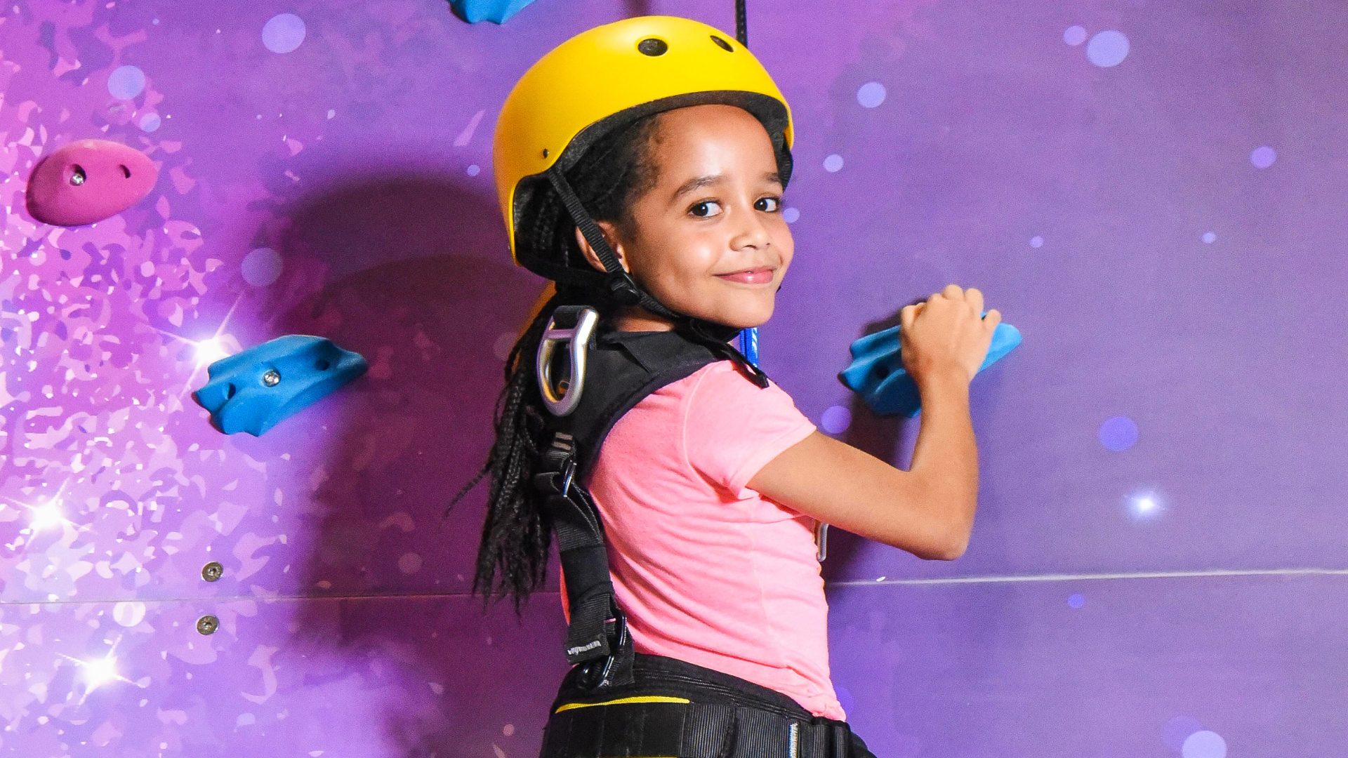 Adventurer scaling the climbing wall at The Hub Park, a fun center near me for families in Nairobi.